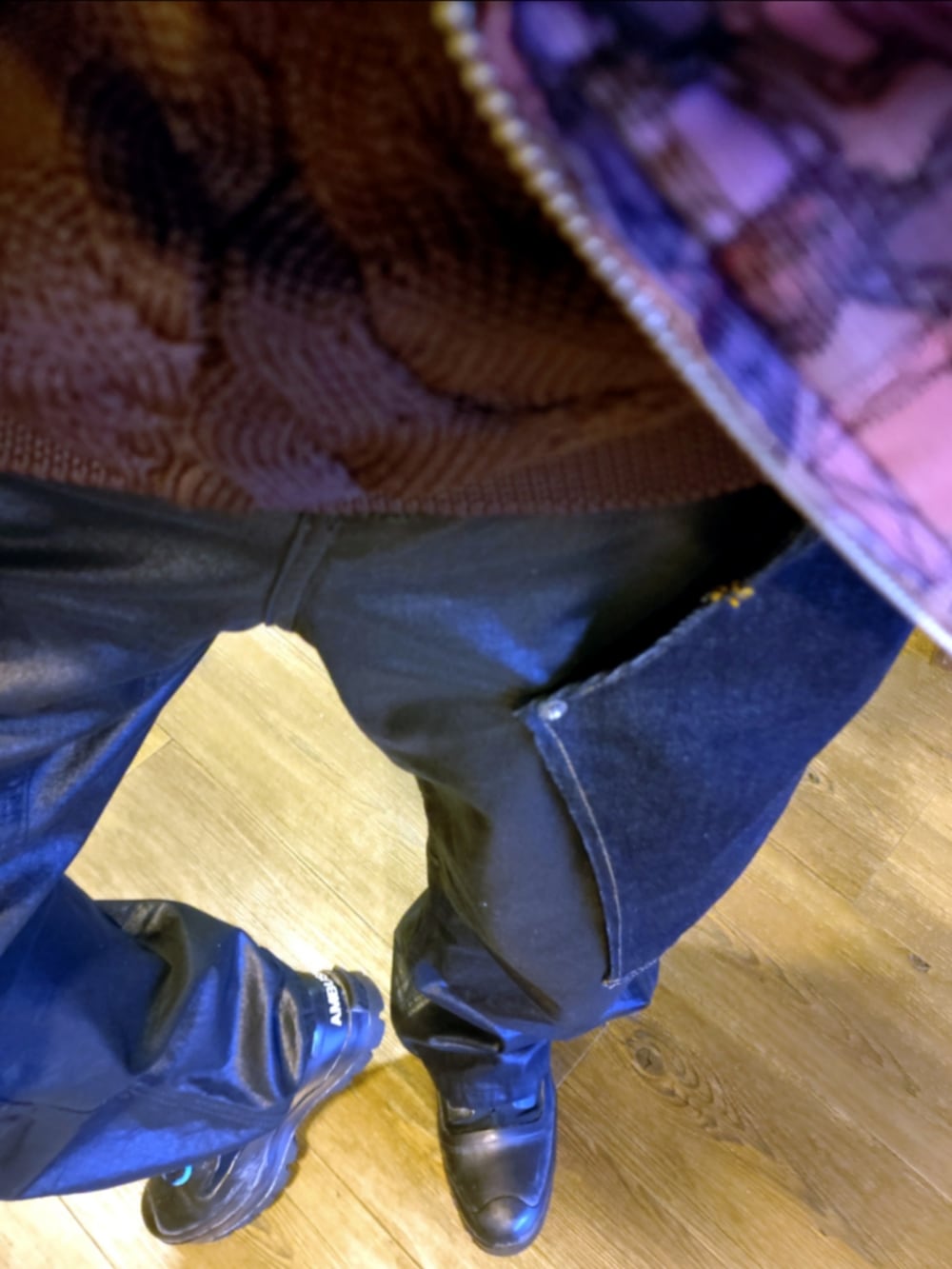 ピンク系のブルゾン、パープル系のニット/セーター、ブルー系のデニムパンツを着用したメンズの秋コーディネートの4枚目の写真