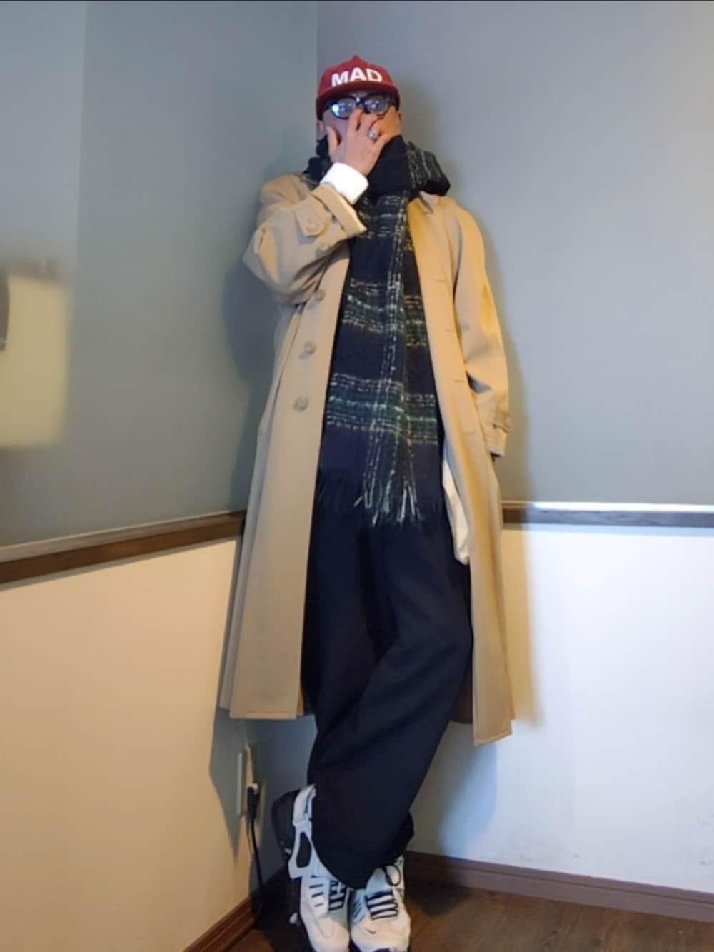 ベージュ系のトレンチコート、ブラック系のパーカー、ブラック系のその他パンツを着用したメンズの秋コーディネートの2枚目の写真