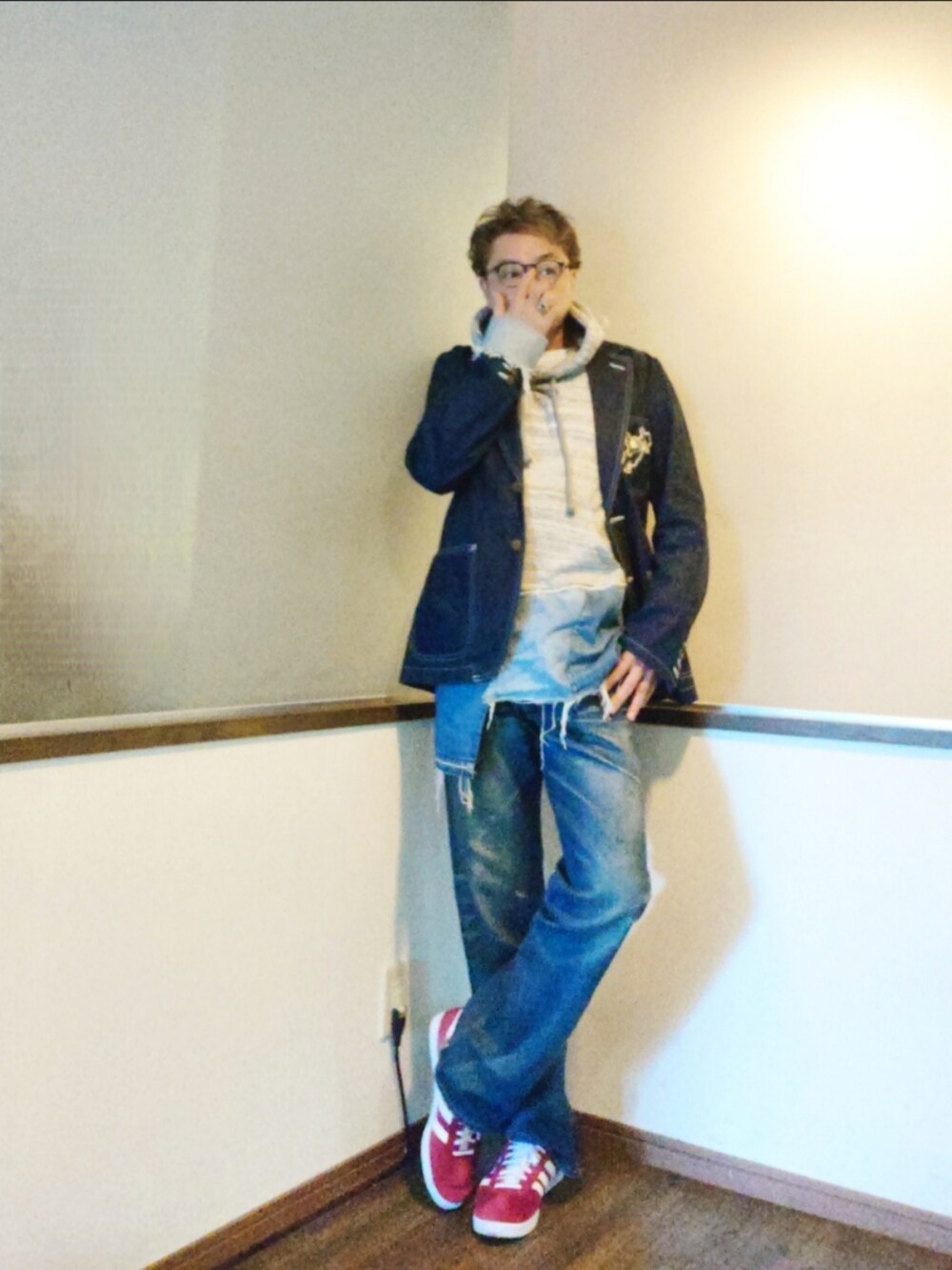 グレー系のパーカー、ブルー系のテーラードジャケット、ブルー系のデニムパンツを着用したメンズの秋コーディネートの2枚目の写真