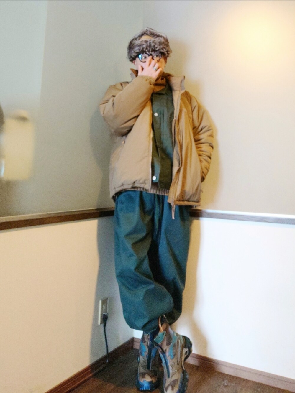 ベージュ系のダウンジャケット/コート、グリーン系のブルゾン、グリーン系のパンツを着用したメンズの秋コーディネートの3枚目の写真