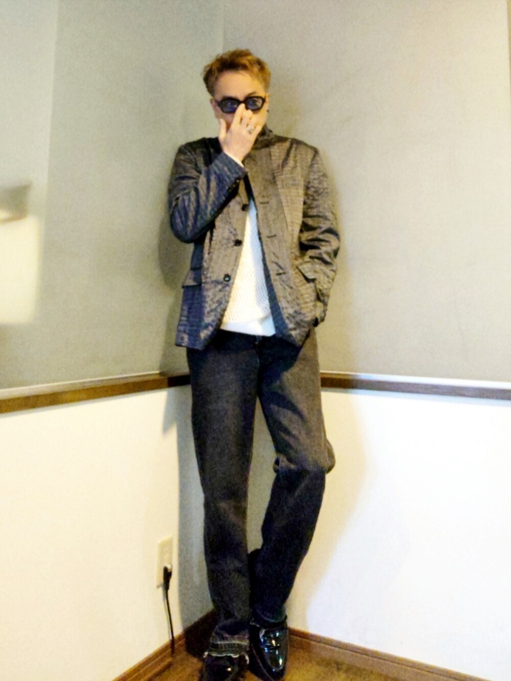 シルバー系のテーラードジャケット、ブラック系のドレスシューズ、ブラック系のデニムパンツを着用したメンズの夏コーディネートの2枚目の写真