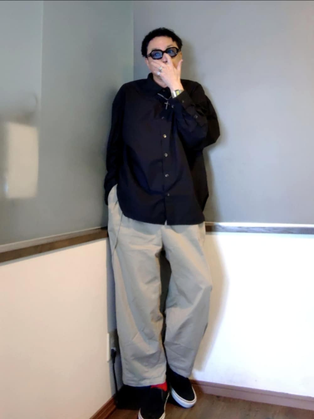 ブラック系のシャツ/ブラウス、ベージュ系のチノパンツ、ブラック系のスニーカーを着用したメンズの夏コーディネートの2枚目の写真