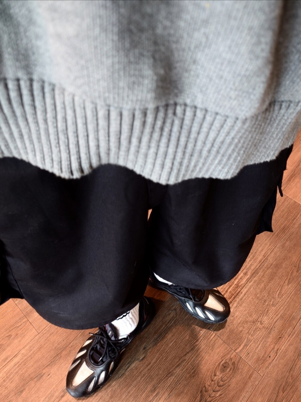 ブラック系のスニーカー、ブラック系のカーゴパンツ、グレー系のベストを着用したメンズの夏コーディネートの3枚目の写真