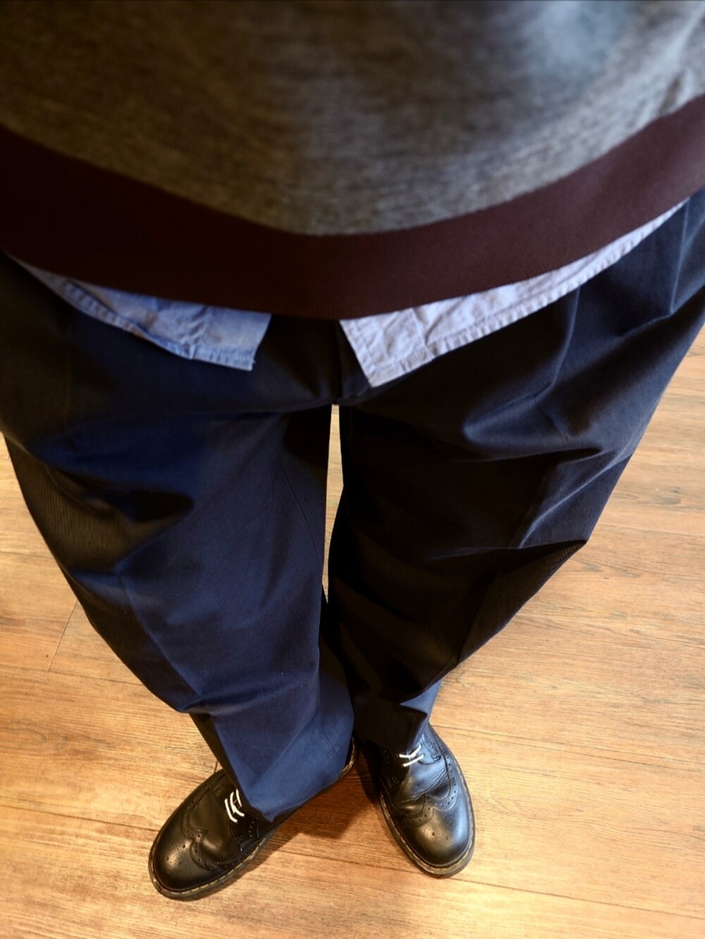 グレー系のベスト、グレー系のスラックス、ブラック系のドレスシューズを着用したメンズの秋コーディネートの2枚目の写真