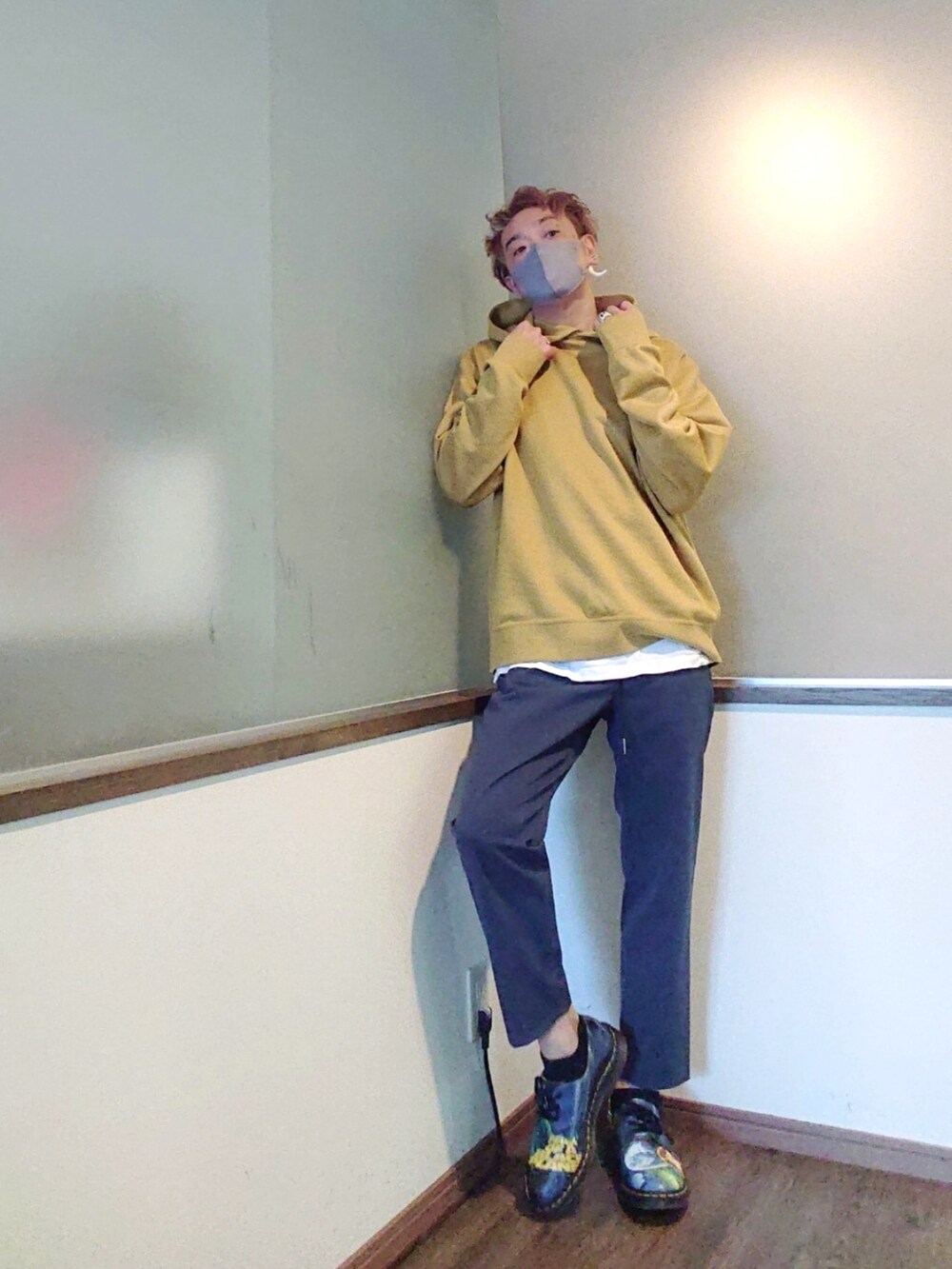 イエロー系のパーカー、グレー系のその他パンツ、ブルー系のシューズを着用したメンズの春コーディネートの2枚目の写真