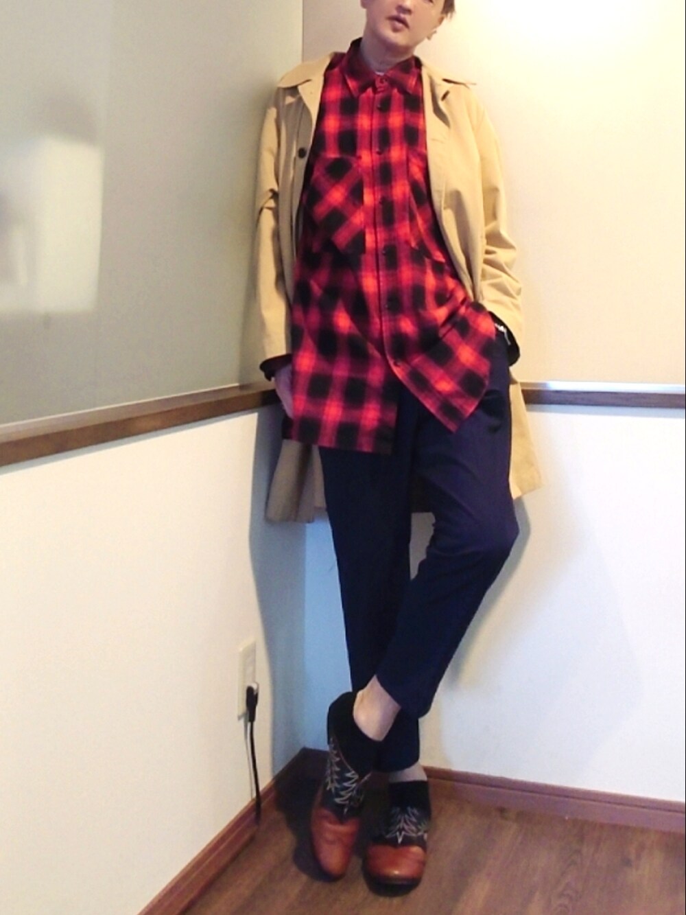 ベージュ系のステンカラーコート、レッド系のシャツ/ブラウス、ブルー系のスラックスを着用したメンズの春コーディネートの3枚目の写真