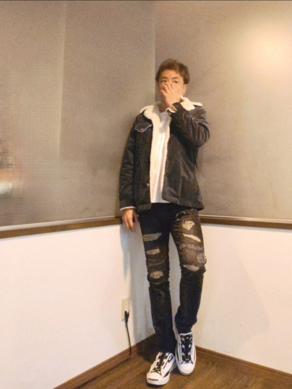 グレー系のブルゾン、ブラック系のデニムパンツ、ホワイト系のスニーカーを着用したメンズの秋コーディネートの2枚目の写真