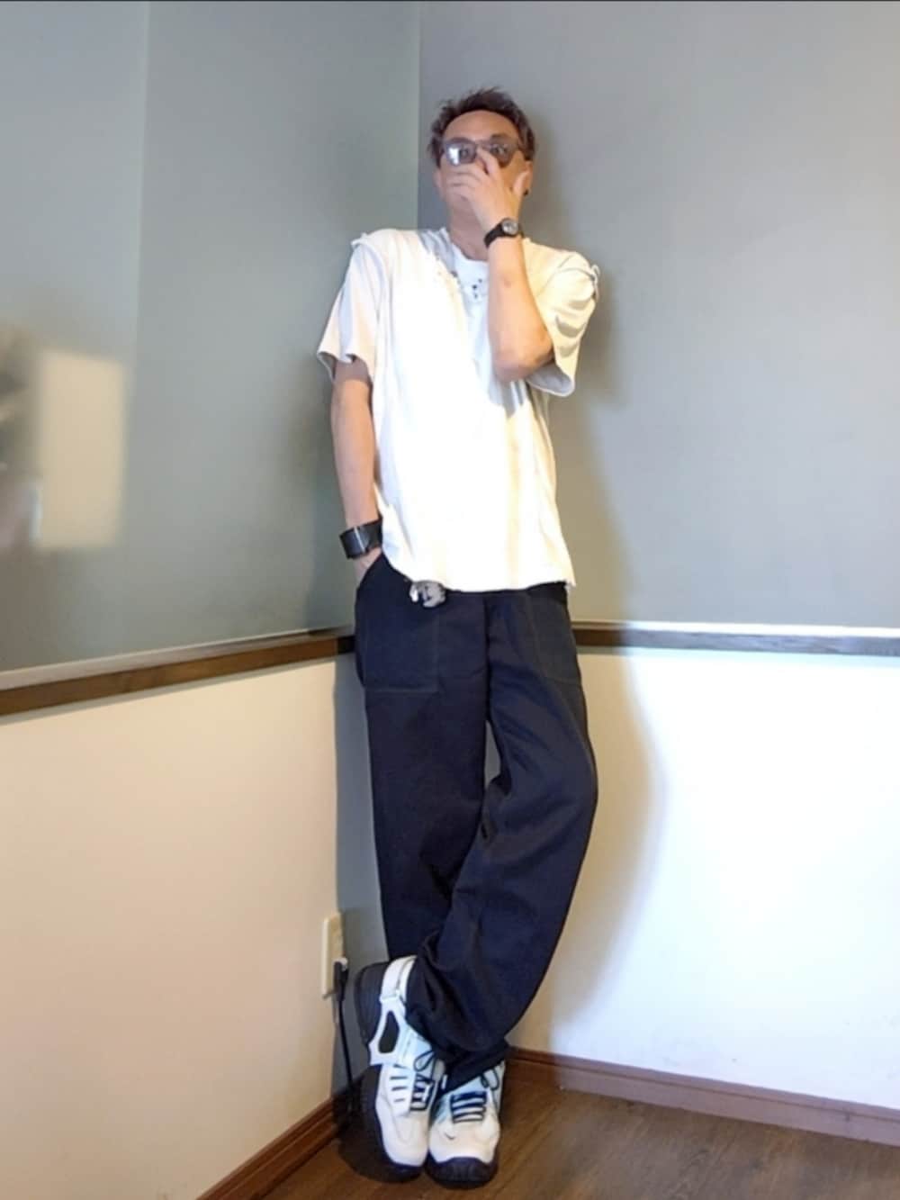 ブラック系のチノパンツ、ホワイト系のTシャツ/カットソー、ホワイト系のスニーカーを着用したメンズの夏コーディネートの2枚目の写真