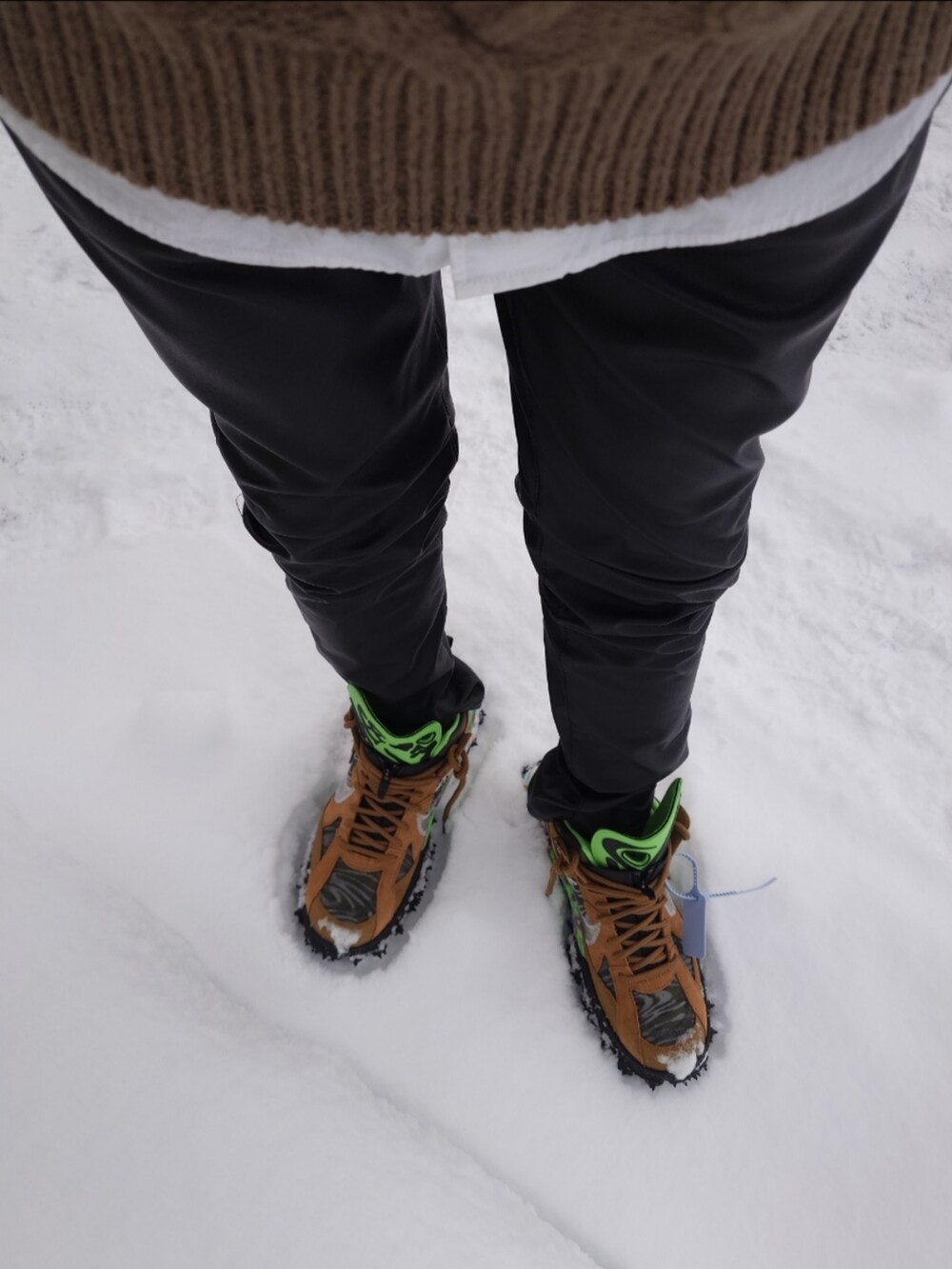 ベージュ系のニット/セーター、ブラック系のダウンジャケット/コート、ブラック系のその他パンツを着用したメンズの冬コーディネートの2枚目の写真