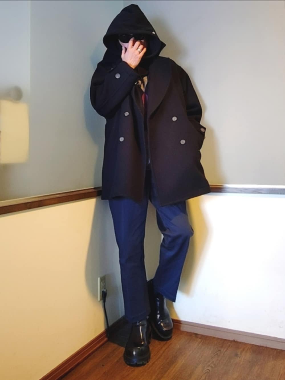 ブラック系のピーコート、ブルー系のチノパンツ、ブラック系のニット/セーターを着用したメンズの冬コーディネートの2枚目の写真