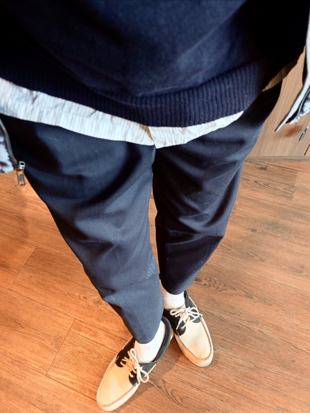 ブルー系のブルゾン、ブルー系のニット/セーター、ブルー系のチノパンツを着用したメンズの冬コーディネートの3枚目の写真