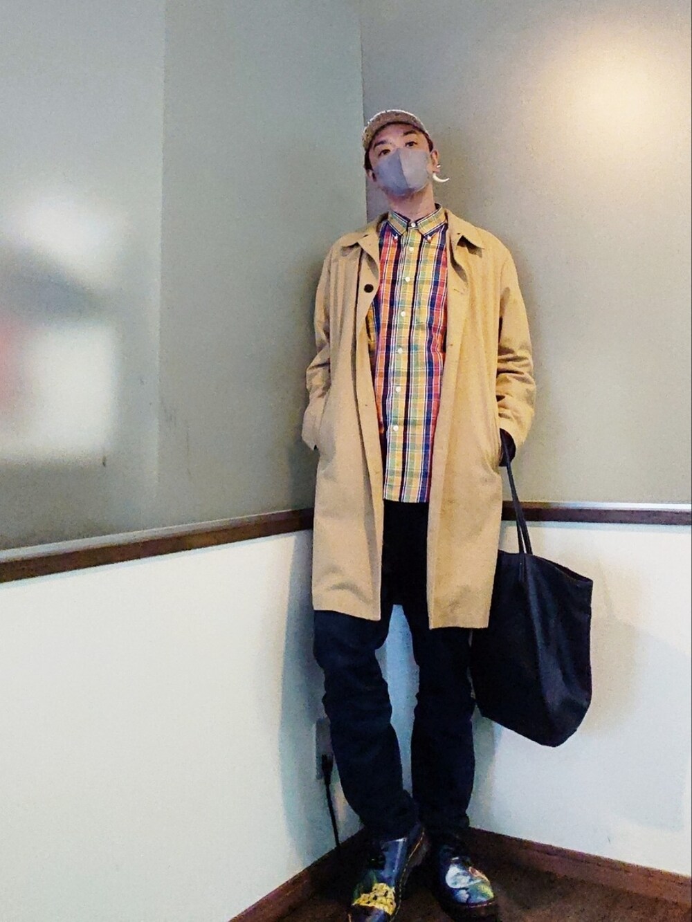 ベージュ系のステンカラーコート、イエロー系のシャツ/ブラウス、ブルー系のパンツを着用したメンズの春コーディネートの3枚目の写真