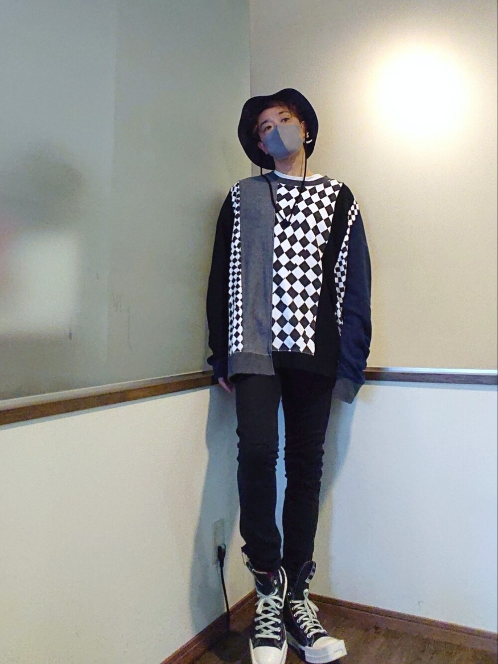 グレー系のスウェット、ブラック系のデニムパンツ、ブラック系のスニーカーを着用したメンズの春コーディネートの2枚目の写真