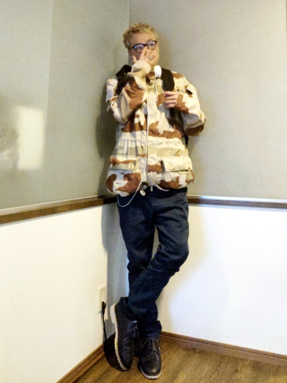 ブラウン系のベスト、ベージュ系のミリタリージャケット、ブラック系のバックパック/リュックを着用したメンズの春コーディネートの3枚目の写真