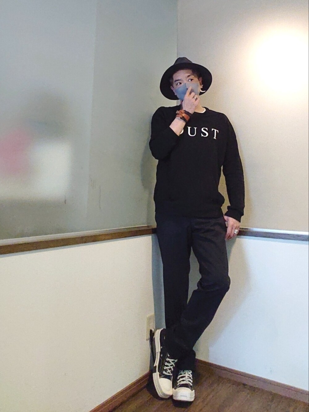 ブラック系のスウェット、ブラック系のスラックス、ブラック系のスニーカーを着用したメンズの春コーディネートの3枚目の写真