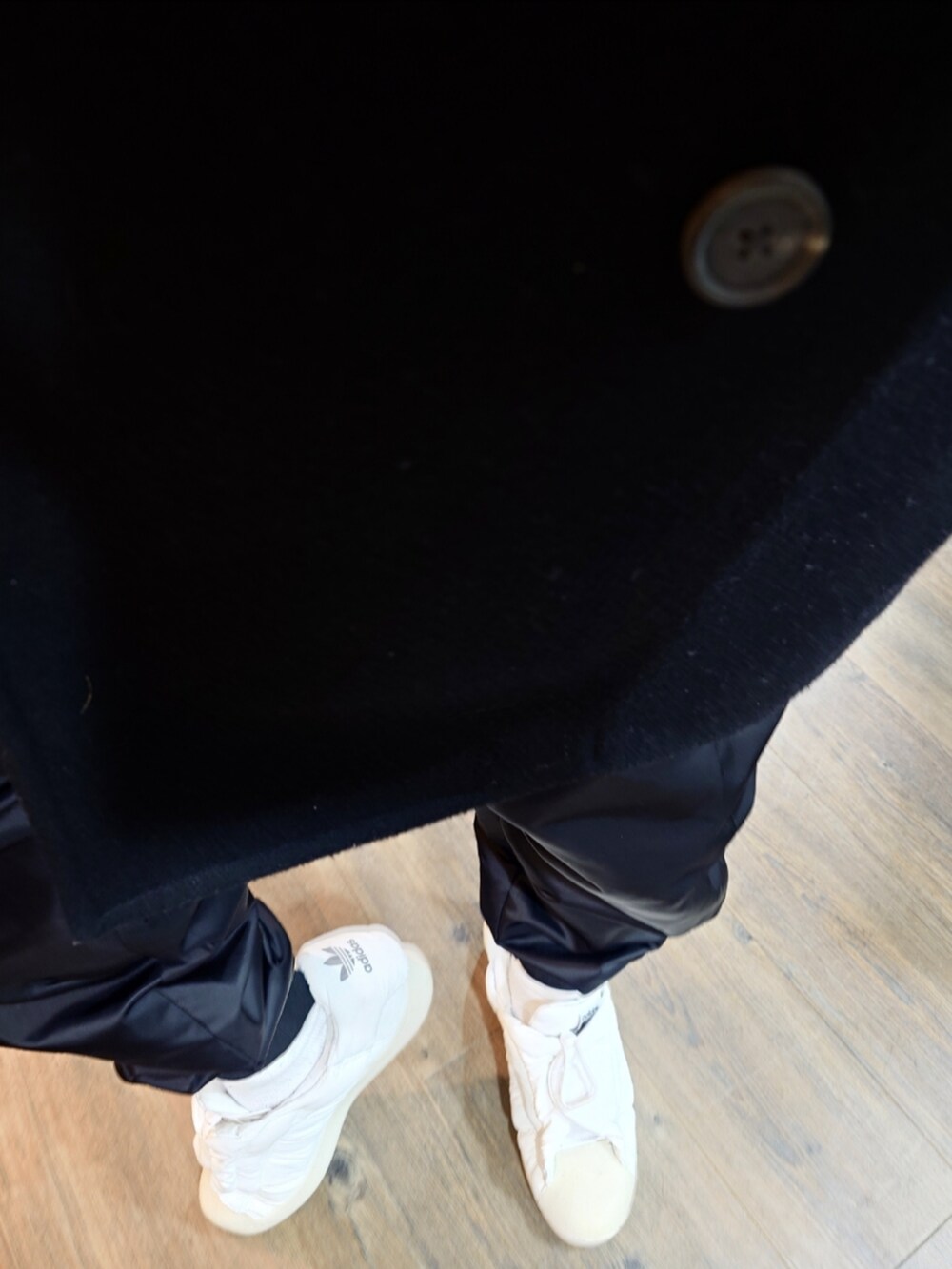 グレー系のパーカー、ブラック系のピーコート、ホワイト系のシャツ/ブラウスを着用したメンズの冬コーディネートの3枚目の写真