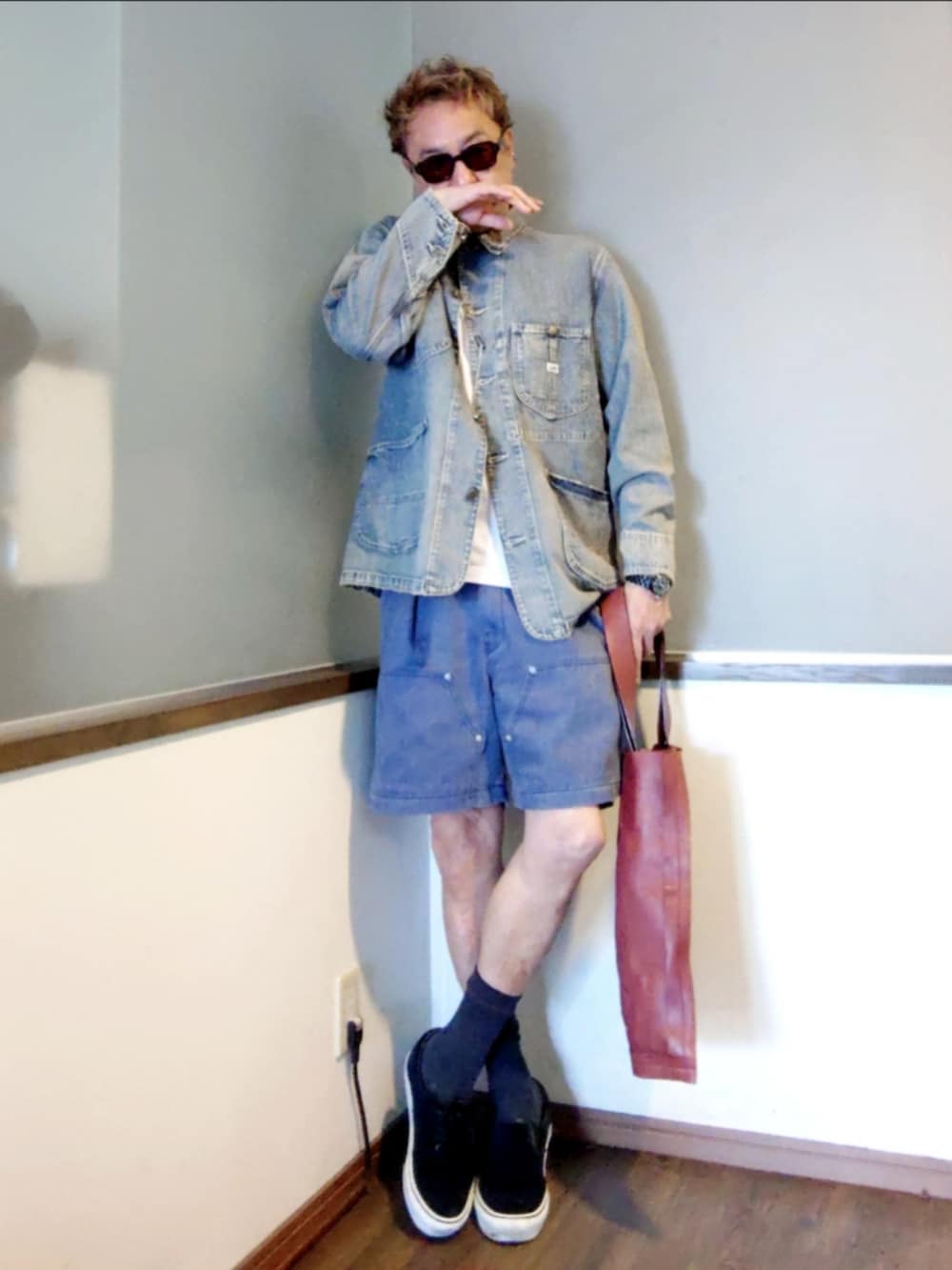 レッド系のトートバッグ、ブルー系のその他パンツ、ブラック系のスニーカーを着用したメンズの夏コーディネートの2枚目の写真