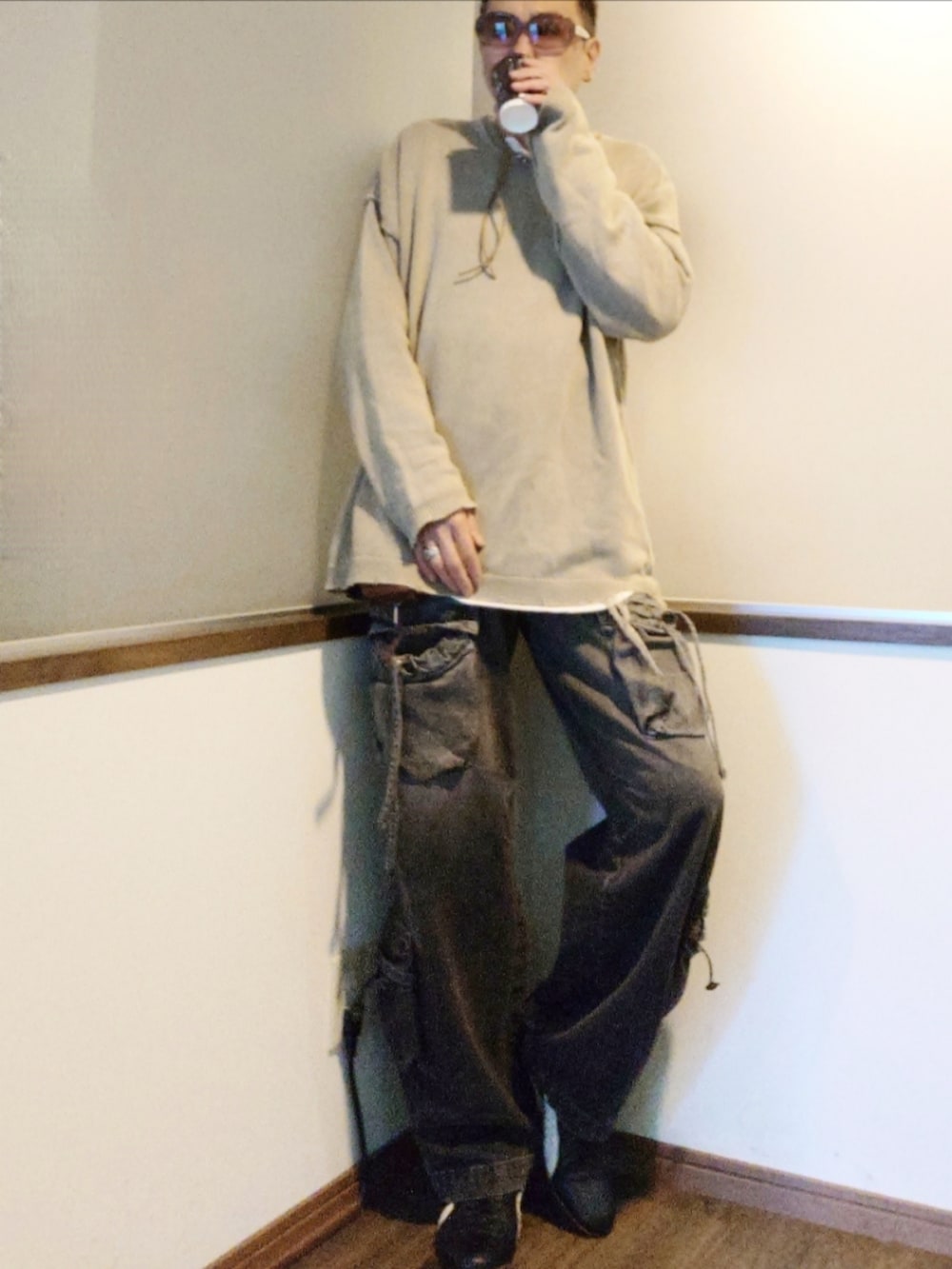 ブラック系のスニーカー、ブラック系のカーゴパンツ、ベージュ系のニット/セーターを着用したメンズの秋コーディネートの2枚目の写真