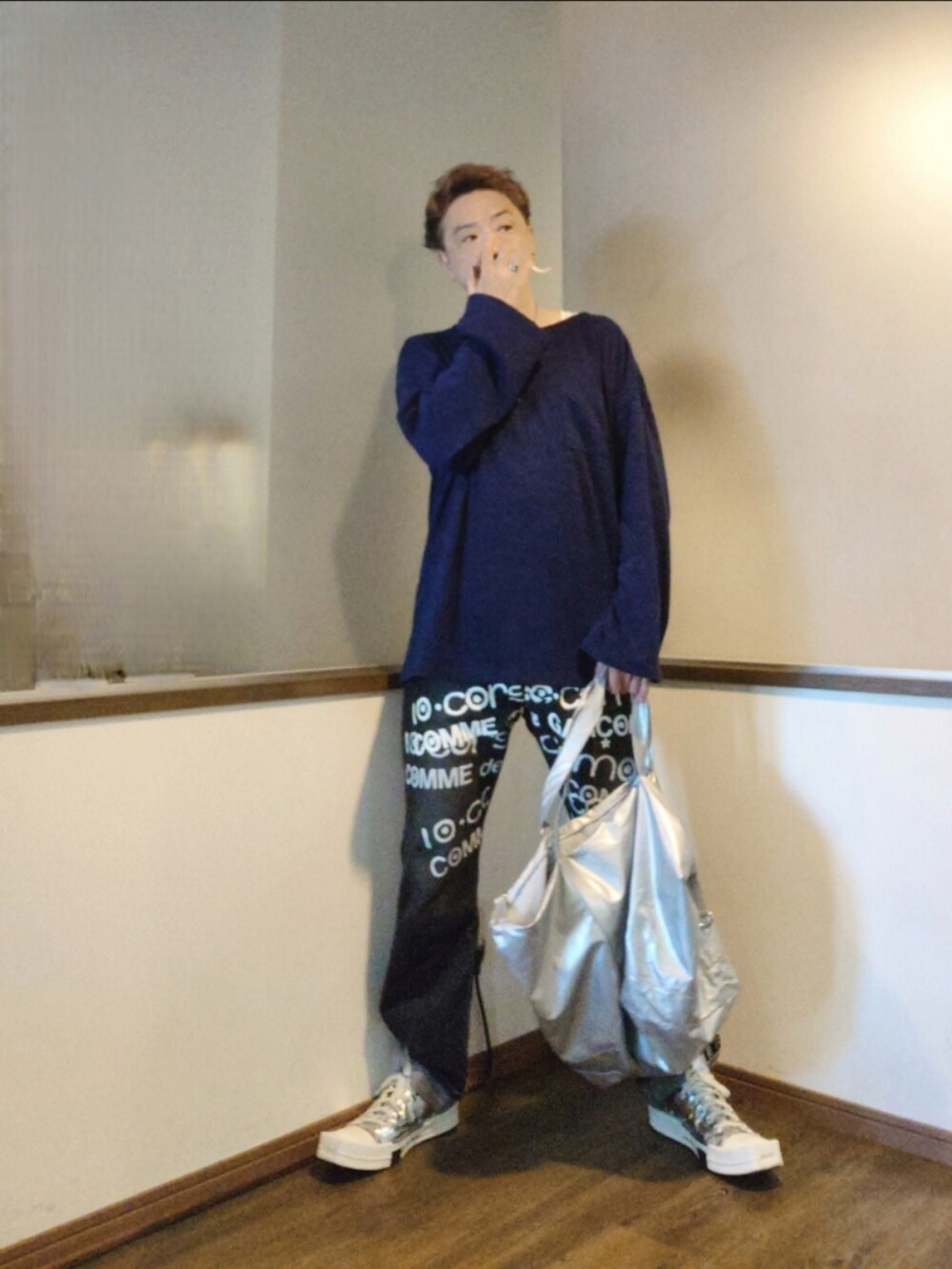 ブルー系のニット/セーター、シルバー系のトートバッグ、ブラック系のデニムパンツを着用したメンズの秋コーディネートの3枚目の写真