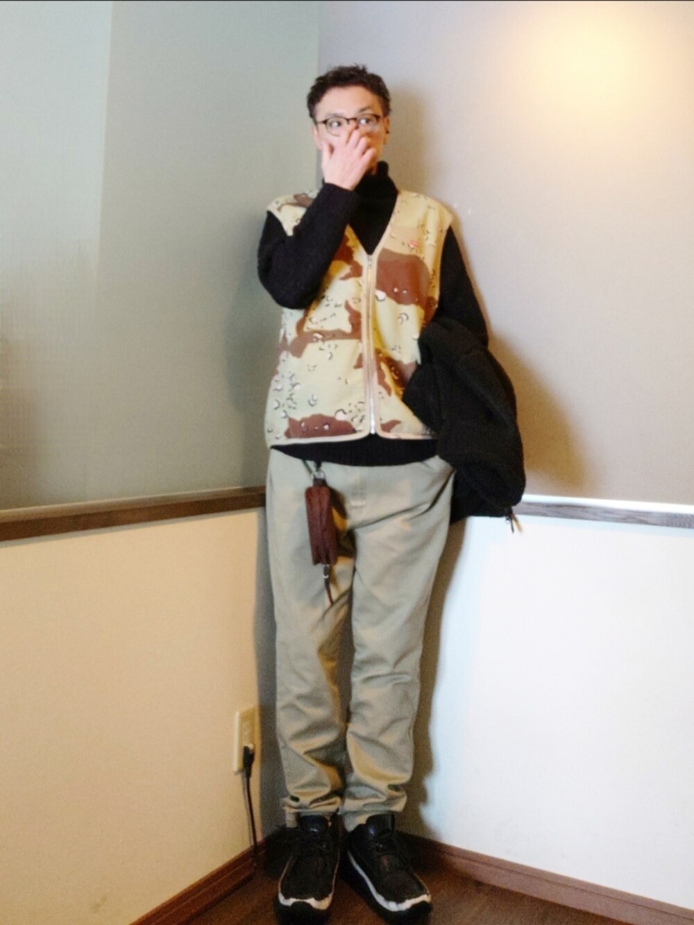 ブラック系のブルゾン、ブラウン系のベスト、グリーン系のチノパンツを着用したメンズの春コーディネートの2枚目の写真