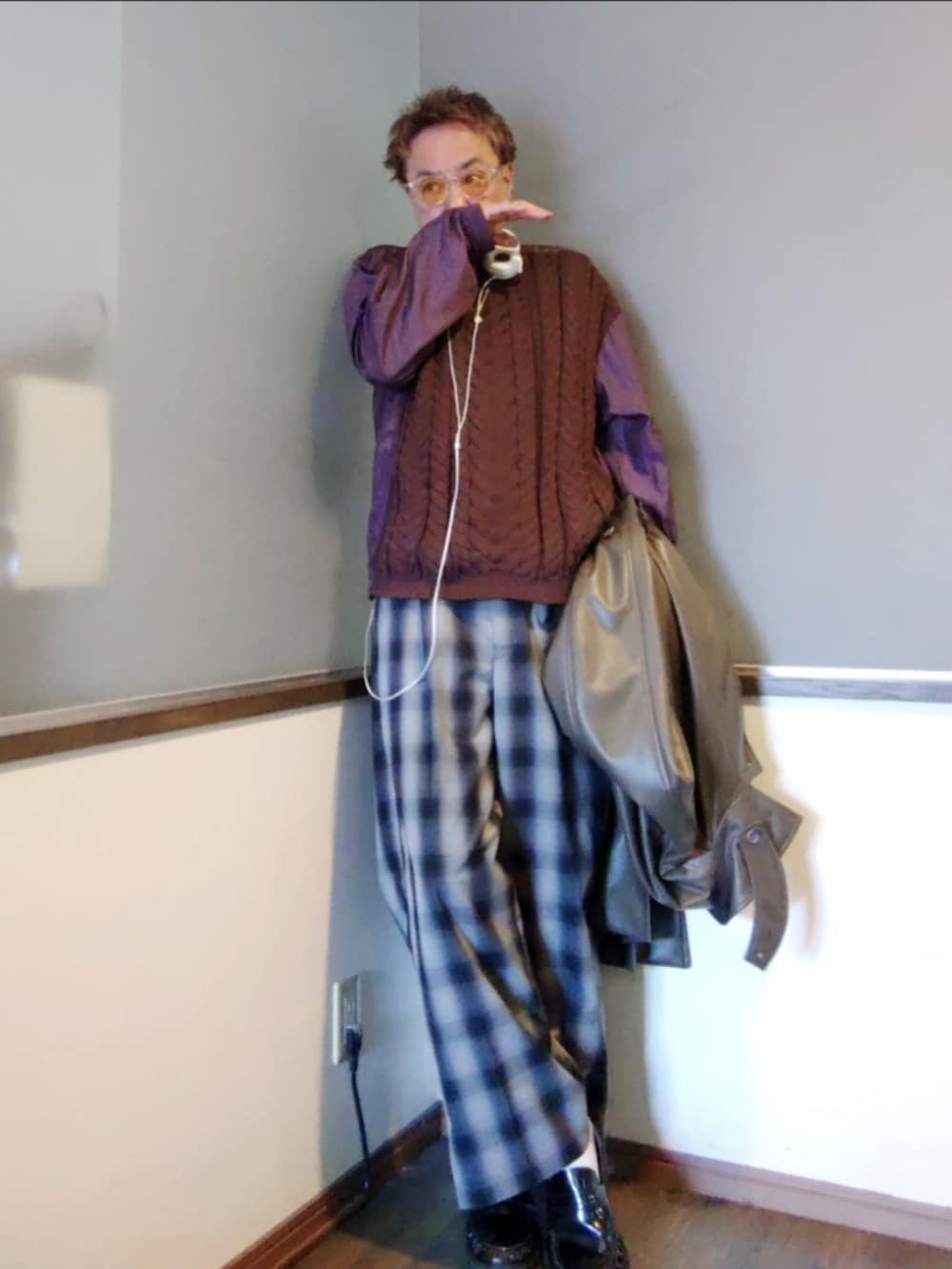 パープル系のニット/セーター、グリーン系のステンカラーコート、ブラック系のローファーを着用したメンズの春コーディネートの3枚目の写真