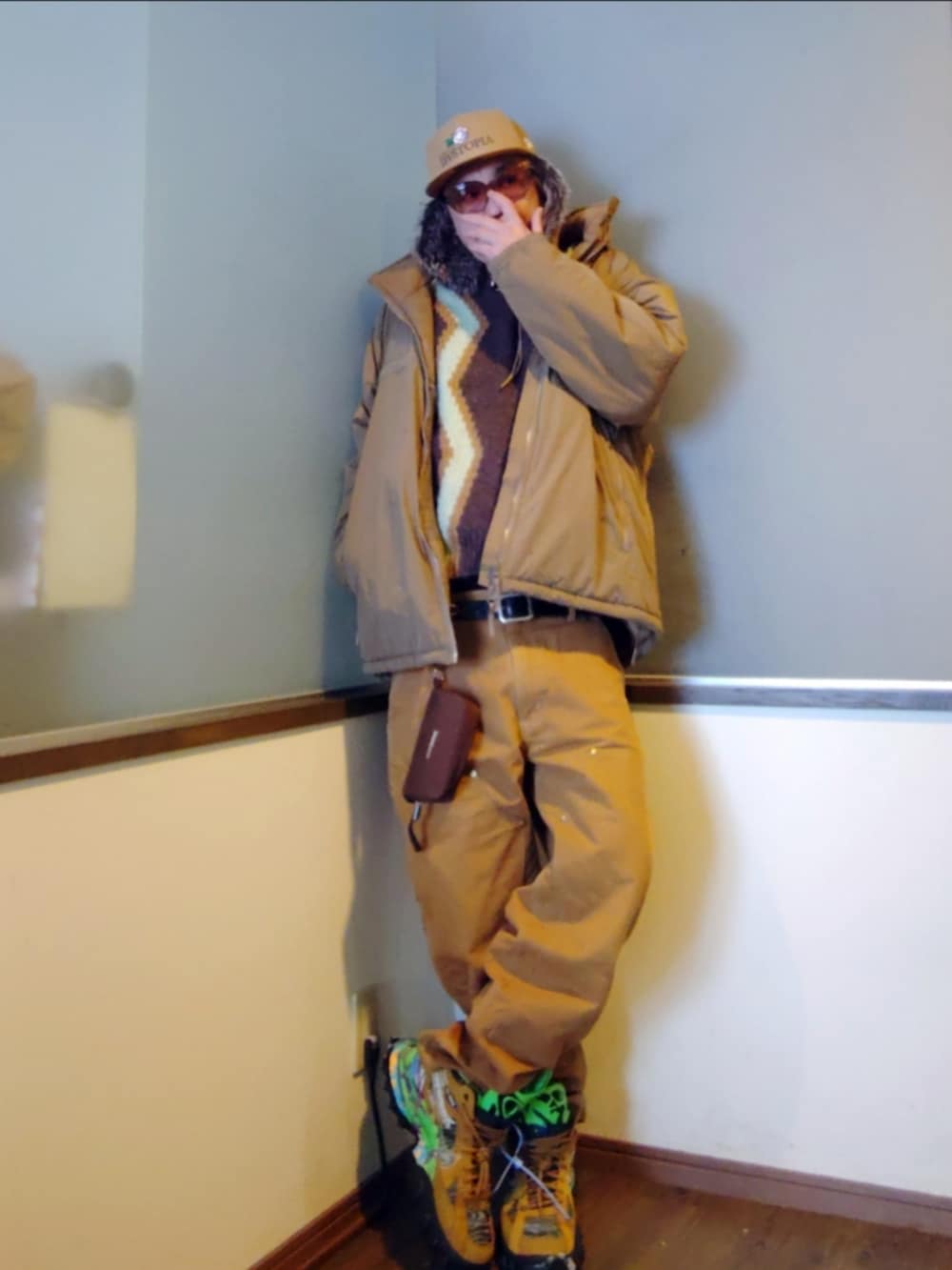 ベージュ系のダウンジャケット/コート、ブラウン系のバッグ、ブラウン系のその他パンツを着用したメンズの冬コーディネートの2枚目の写真