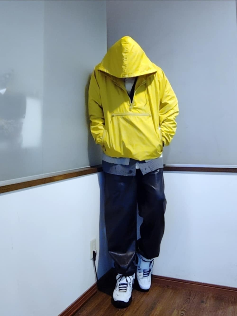 イエロー系のナイロンジャケット、グレー系のカーディガン/ボレロ、ホワイト系のシャツ/ブラウスを着用したメンズの秋コーディネートの3枚目の写真