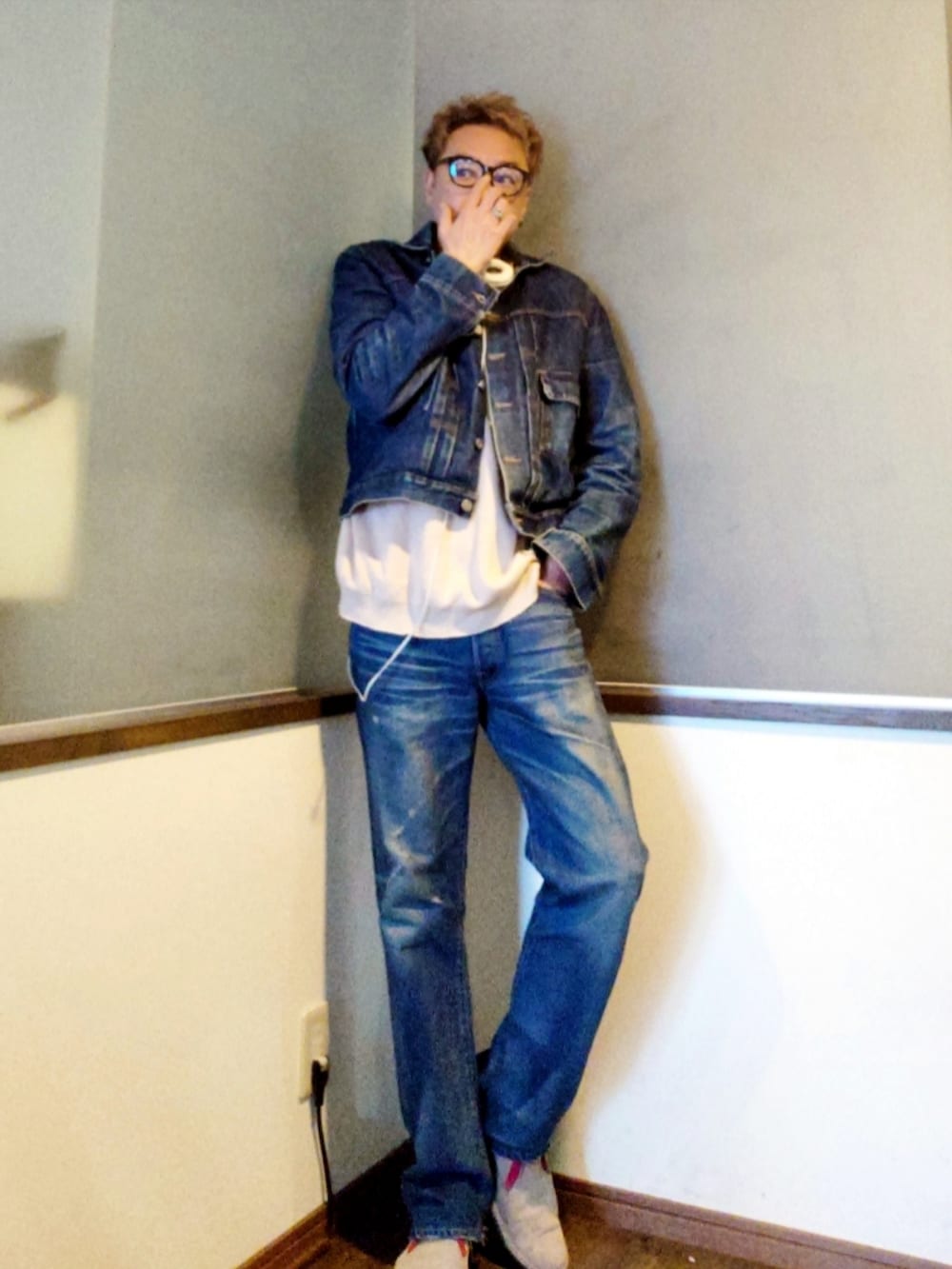 ベージュ系のニット/セーター、ベージュ系のブーツ、ブルー系のデニムパンツを着用したメンズの夏コーディネートの2枚目の写真