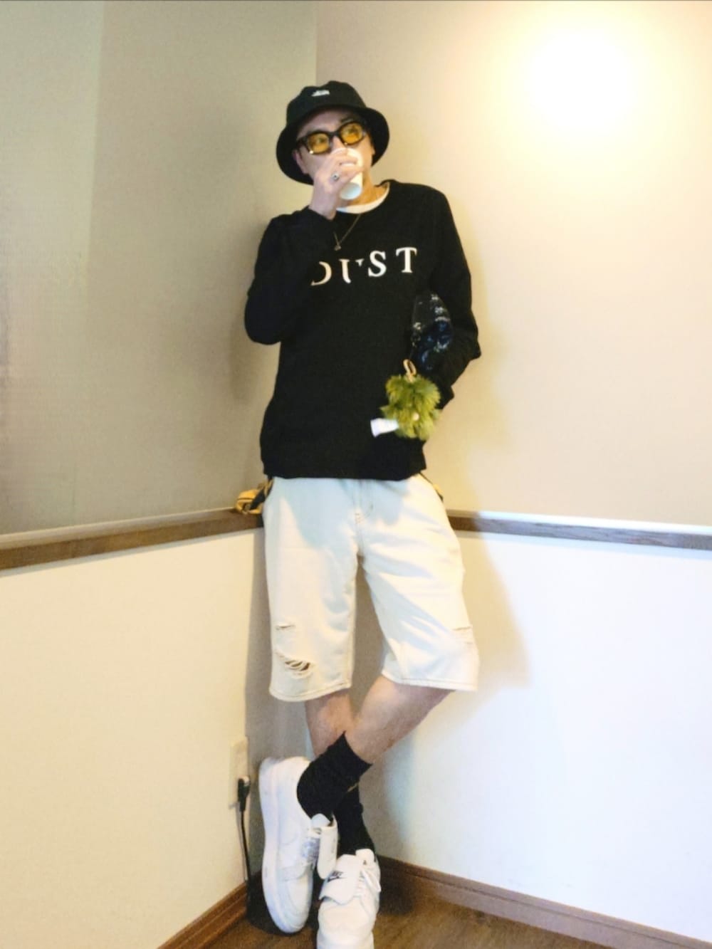 ブラック系のスウェット、ホワイト系のデニムパンツ、ブラック系のクラッチバッグを着用したメンズの夏コーディネートの2枚目の写真