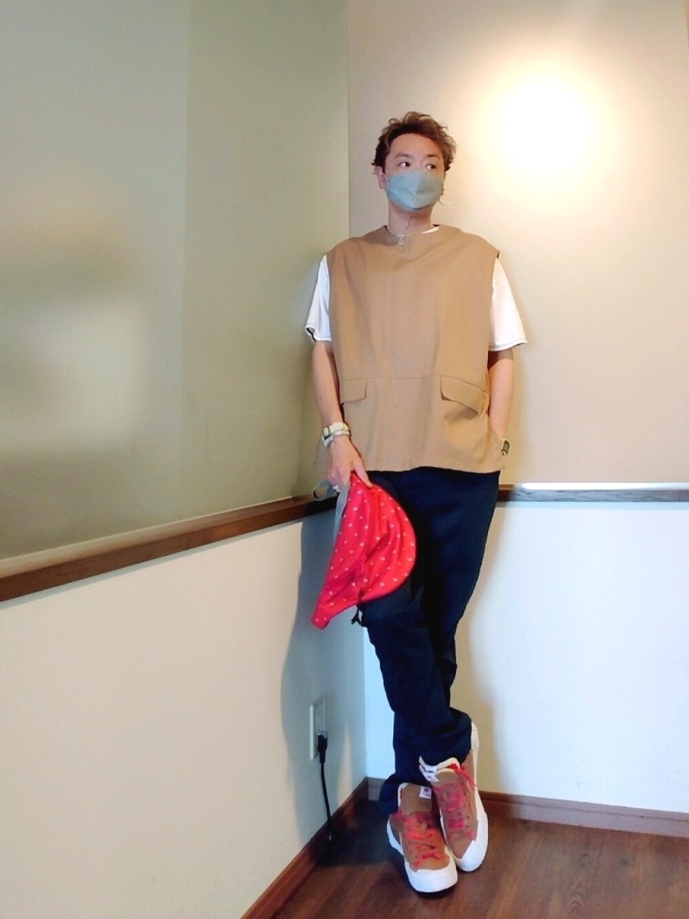 ベージュ系のベスト、レッド系のショルダーバッグ、ホワイト系のTシャツ/カットソーを着用したメンズの秋コーディネートの3枚目の写真