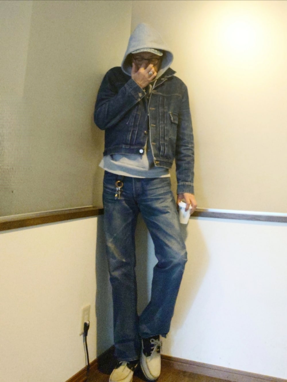 グレー系のパーカー、ブルー系のデニムジャケット、ブルー系のデニムパンツを着用したメンズの秋コーディネートの2枚目の写真