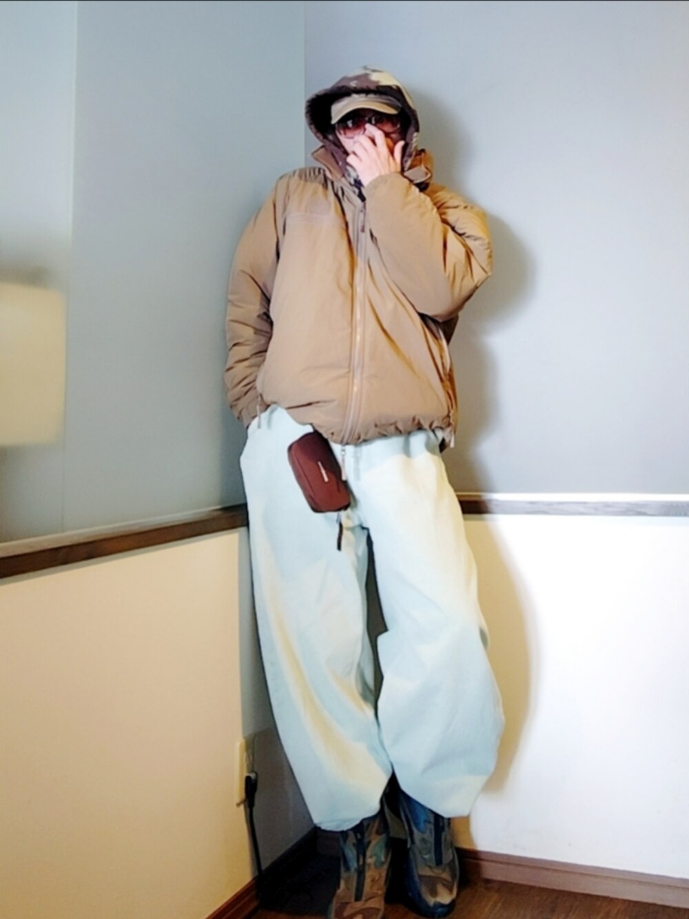 ベージュ系のダウンジャケット/コート、ブラック系のパーカー、ブルー系のデニムパンツを着用したメンズの冬コーディネートの3枚目の写真