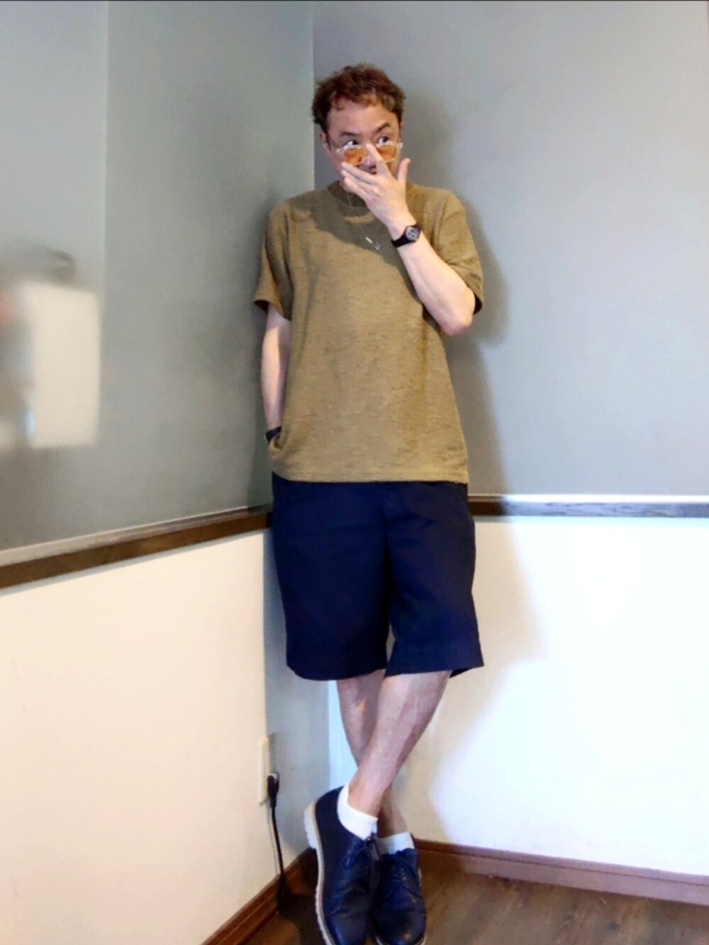 グリーン系のニット/セーター、ブルー系のチノパンツ、ブルー系のブーツを着用したメンズの夏コーディネートの2枚目の写真