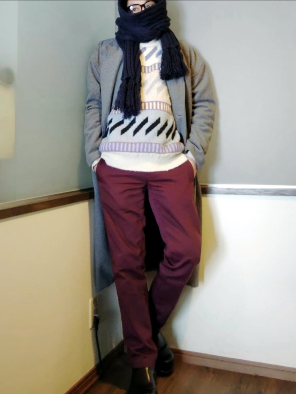 ブルー系のニット/セーター、レッド系のチノパンツ、ブラック系のブーツを着用したメンズの冬コーディネートの3枚目の写真