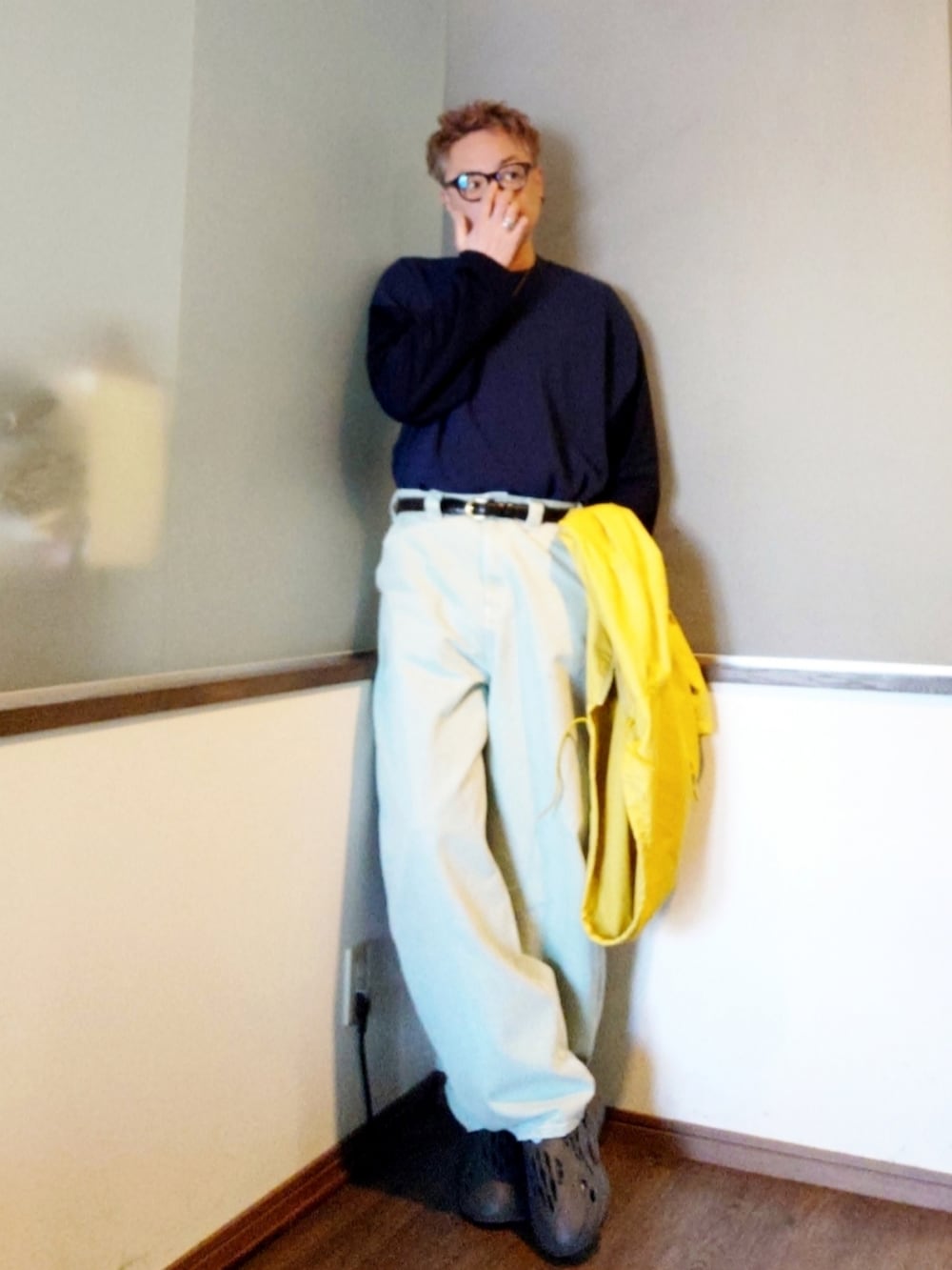 イエロー系のナイロンジャケット、ブルー系のデニムパンツ、グレー系のシューズを着用したメンズの春コーディネートの3枚目の写真