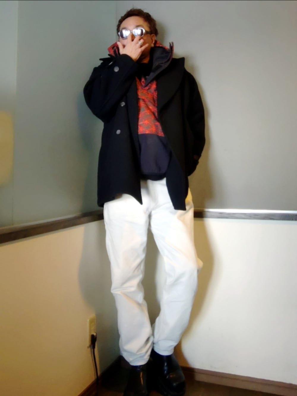 レッド系のブルゾン、ブラック系のピーコート、ホワイト系のデニムパンツを着用したメンズの冬コーディネートの2枚目の写真