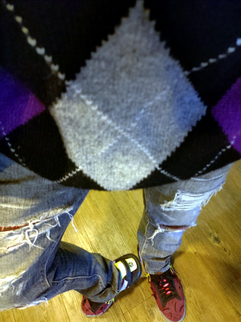 ブラック系のニット/セーター、ブラック系のデニムパンツ、レッド系のスニーカーを着用したメンズの秋コーディネートの4枚目の写真