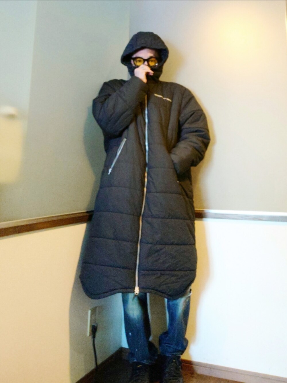 ブラック系のダウンジャケット/コート、ブルー系のデニムパンツ、ブラック系のスニーカーを着用したメンズの冬コーディネートの2枚目の写真