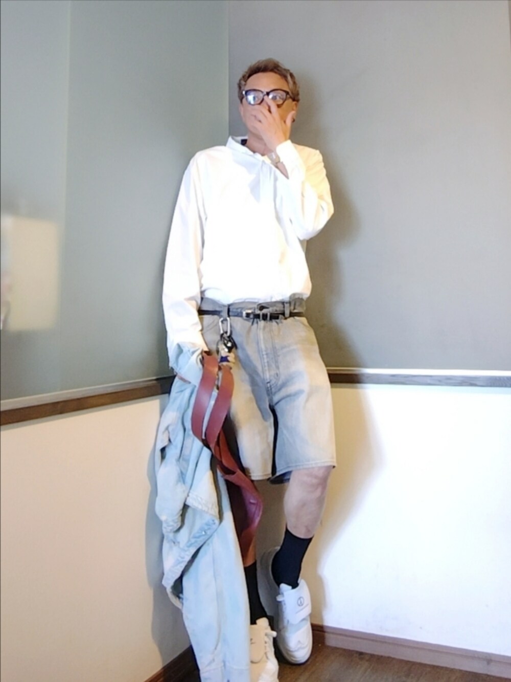 レッド系のトートバッグ、ホワイト系のシャツ/ブラウス、ブルー系のデニムジャケットを着用したメンズの秋コーディネートの2枚目の写真