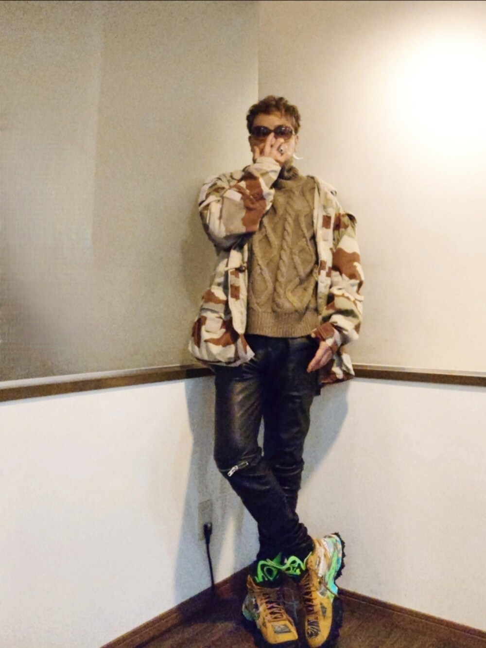 ベージュ系のミリタリージャケット、ブラック系のパンツ、ブラウン系のスニーカーを着用したメンズの秋コーディネートの2枚目の写真