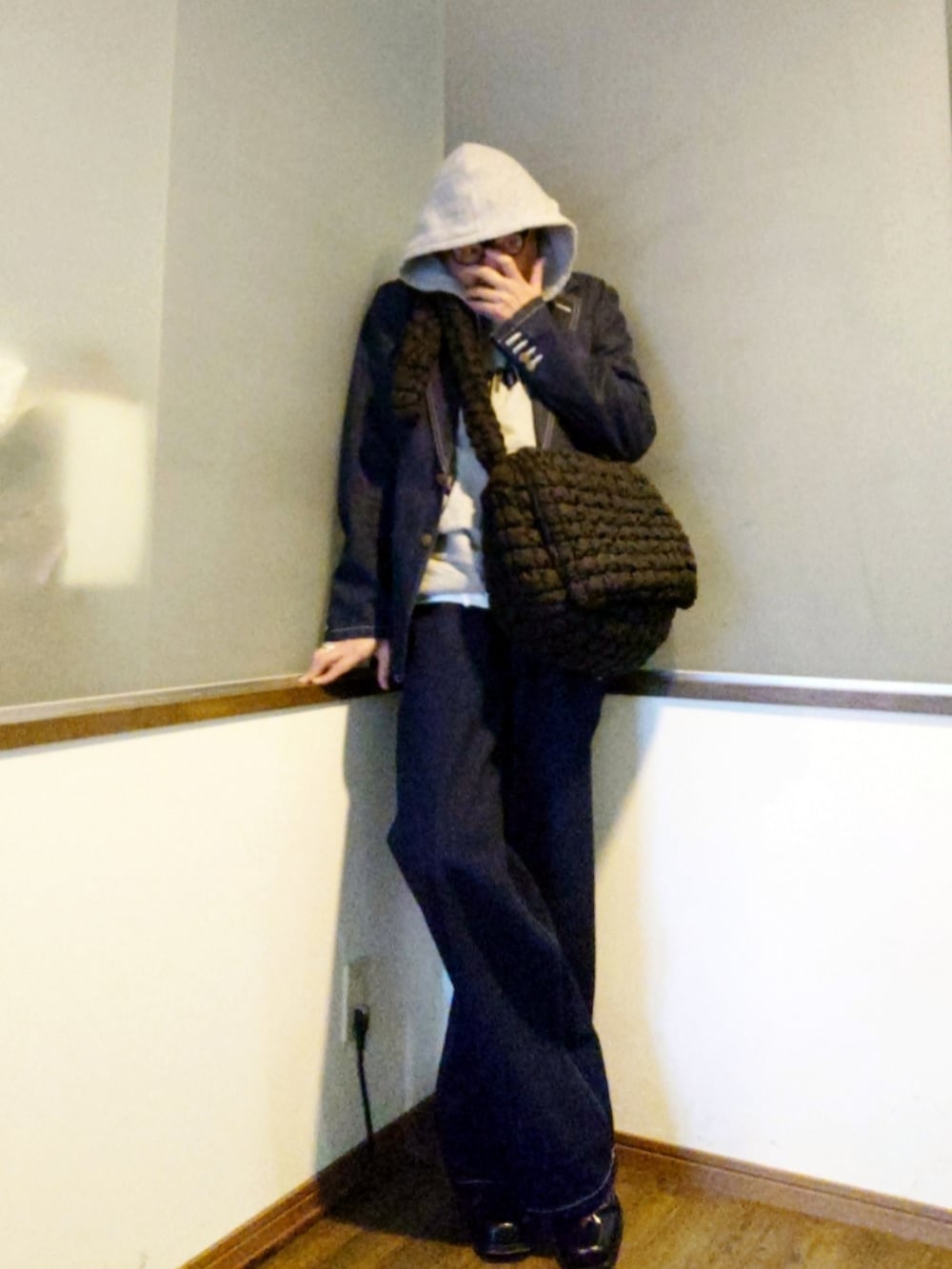 ブルー系のテーラードジャケット、グレー系のパーカー、ブラック系のショルダーバッグを着用したメンズの春コーディネートの2枚目の写真