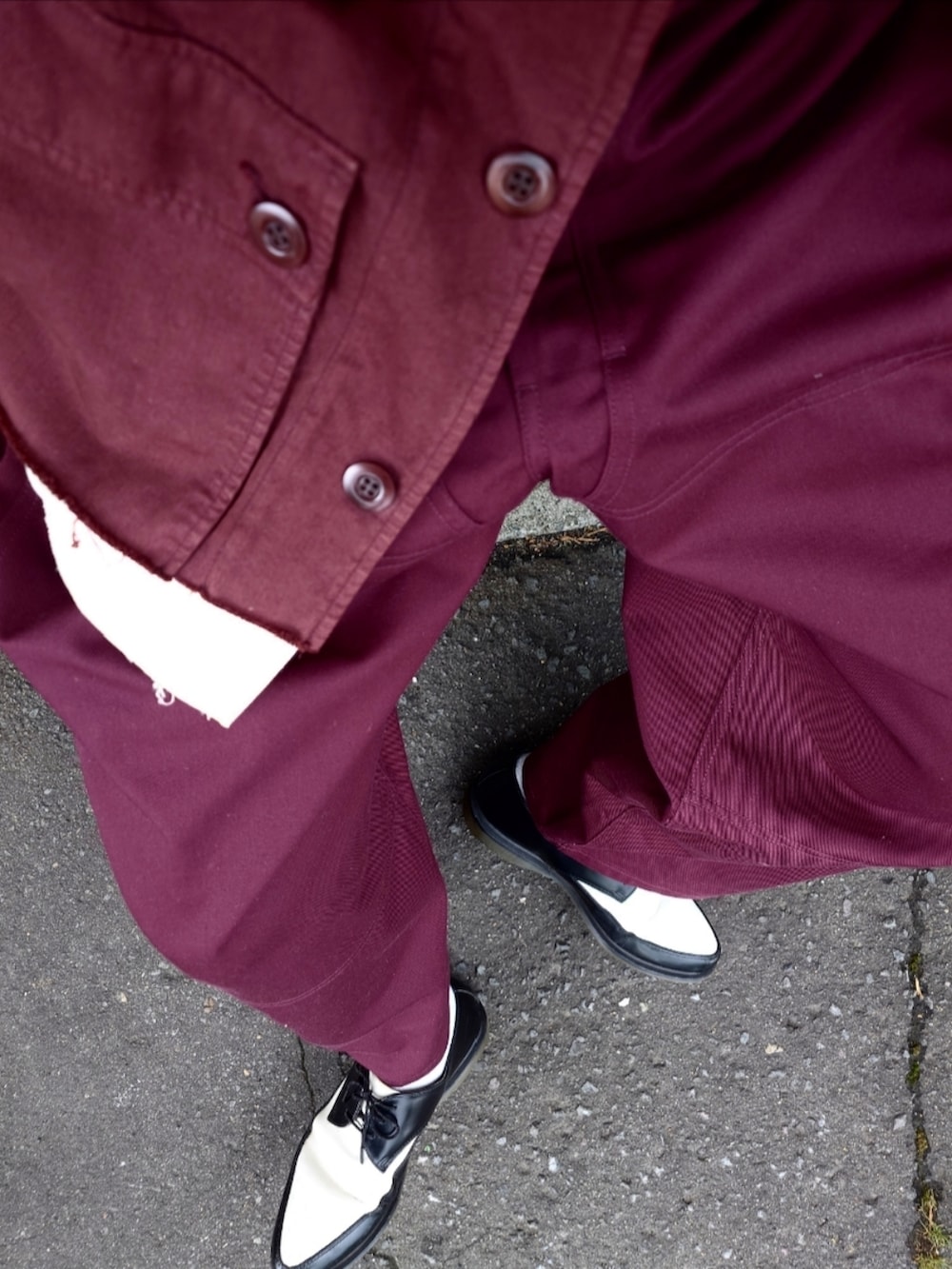 レッド系のカバーオール、レッド系のパンツ、ホワイト系のドレスシューズを着用したメンズの春コーディネートの4枚目の写真