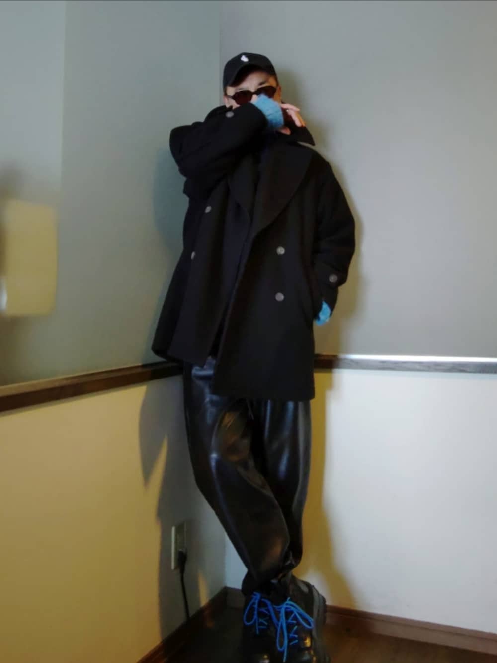 ブラック系のピーコート、ピンク系のTシャツ/カットソー、ブルー系のニット/セーターを着用したメンズの冬コーディネートの3枚目の写真