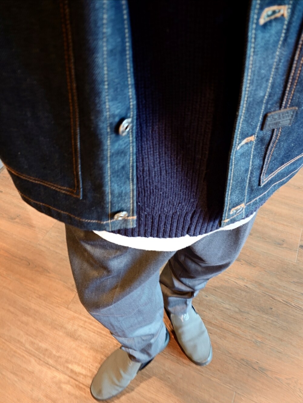 ブルー系のデニムジャケット、グレー系のスラックス、グレー系のスニーカーを着用したメンズの秋コーディネートの3枚目の写真