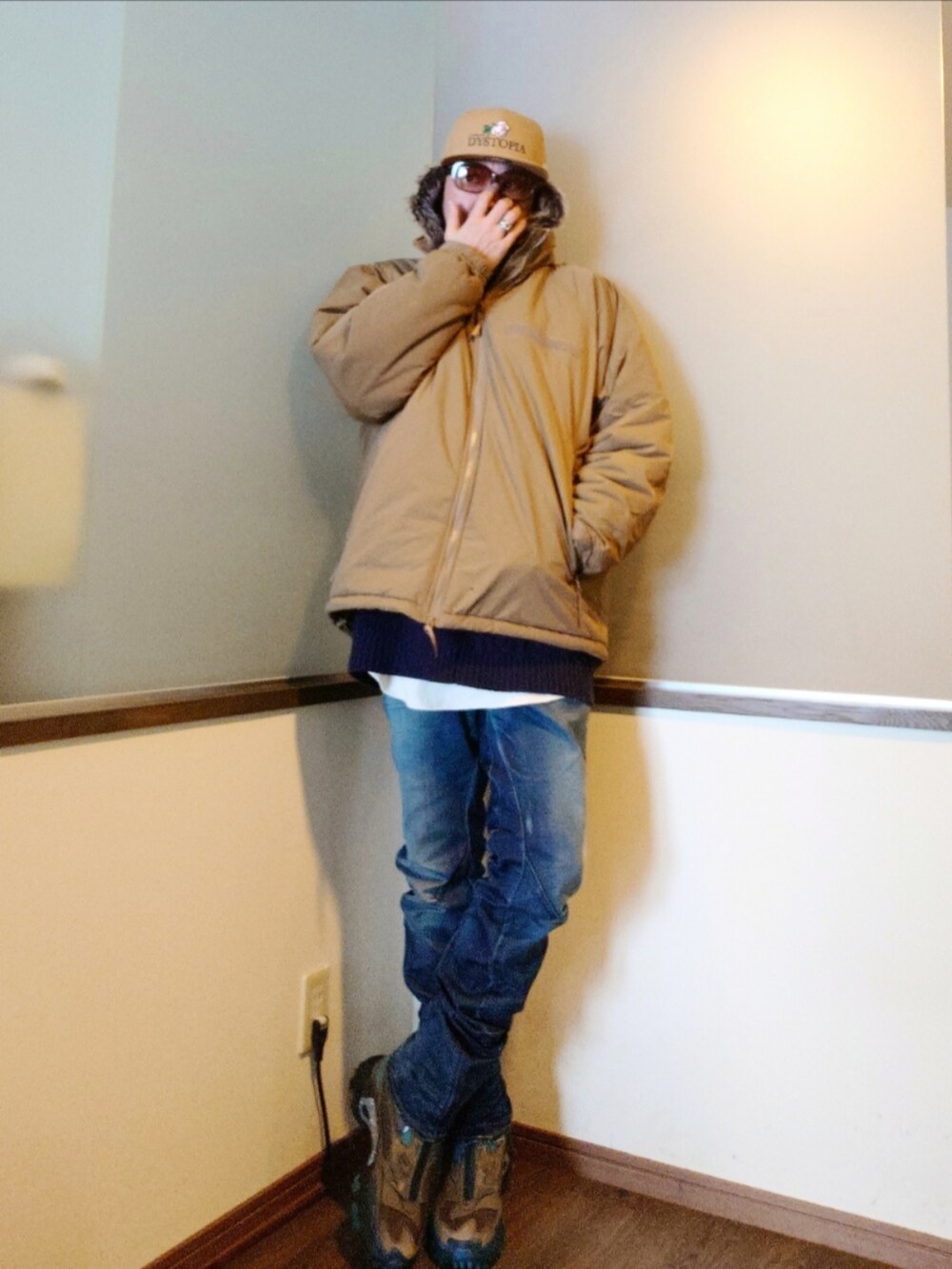 ベージュ系のダウンジャケット/コート、ブルー系のニット/セーター、ブルー系のデニムパンツを着用したメンズの冬コーディネートの2枚目の写真