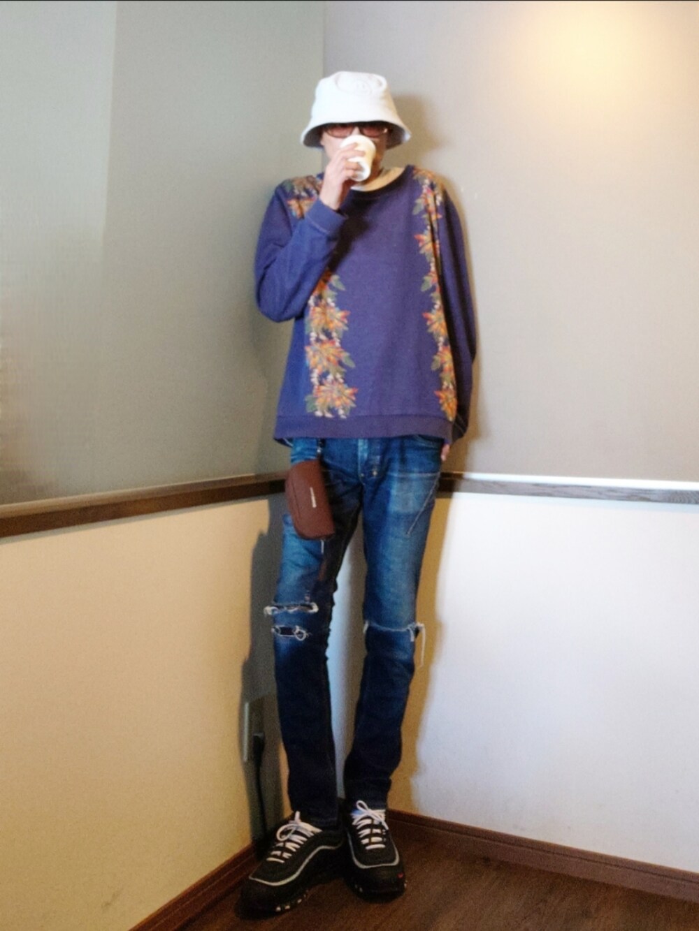 ブルー系のニット/セーター、ホワイト系のダウンジャケット/コート、ブルー系のデニムパンツを着用したメンズの春コーディネートの2枚目の写真