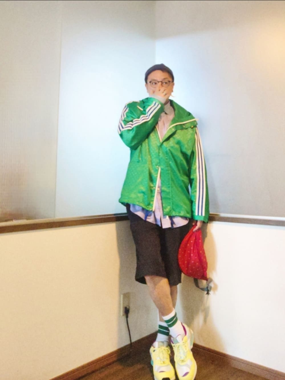 グリーン系のナイロンジャケット、パープル系のシャツ/ブラウス、レッド系のショルダーバッグを着用したメンズの秋コーディネートの2枚目の写真