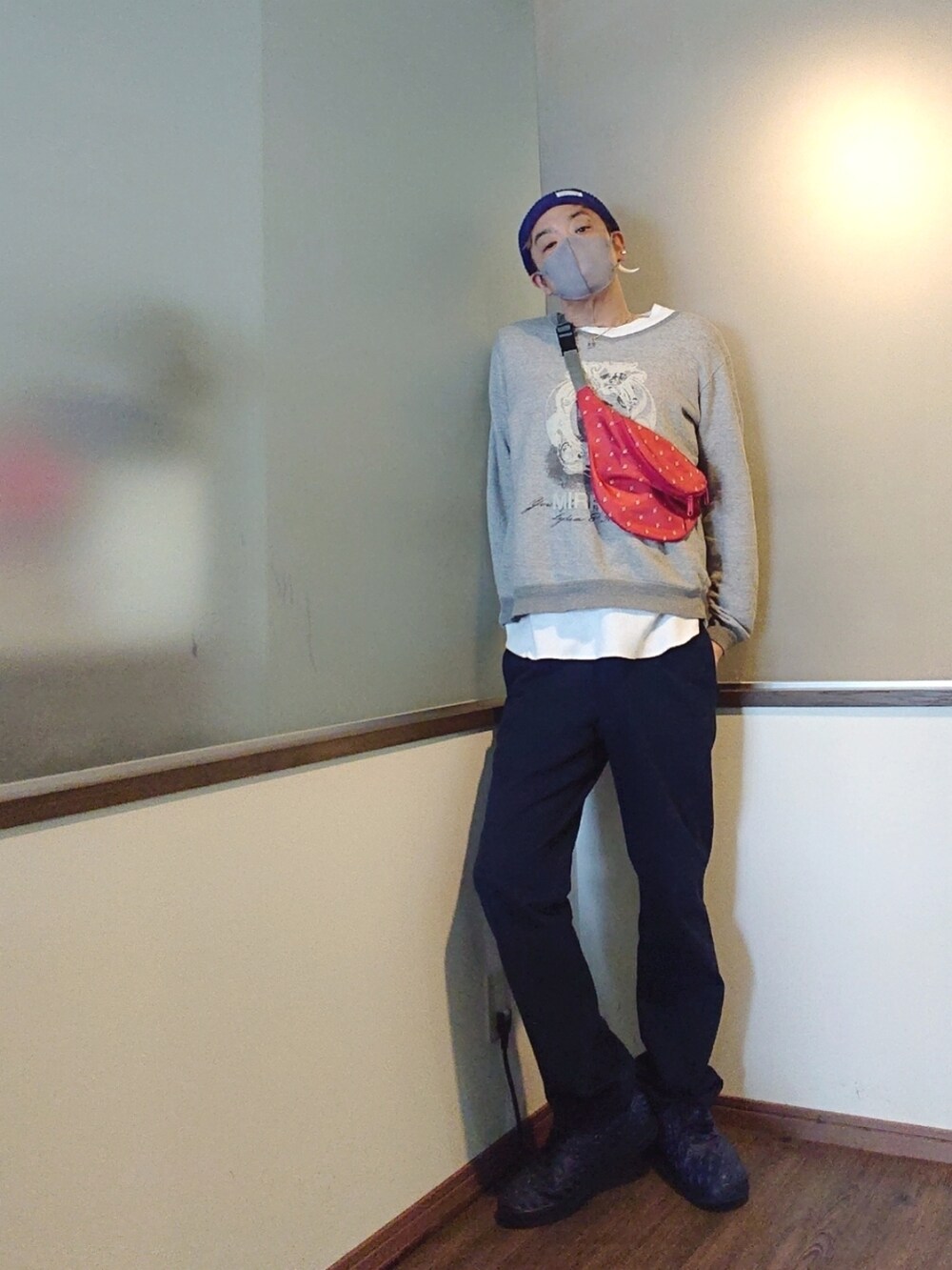 ブルー系のカバーオール、グレー系のスウェット、レッド系のショルダーバッグを着用したメンズの春コーディネートの2枚目の写真