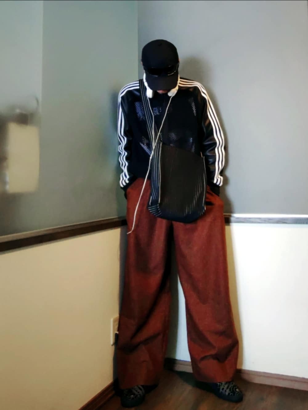 ブラック系のジャージ、ブラウン系のパンツ、ブラック系のニット/セーターを着用したメンズの春コーディネートの3枚目の写真