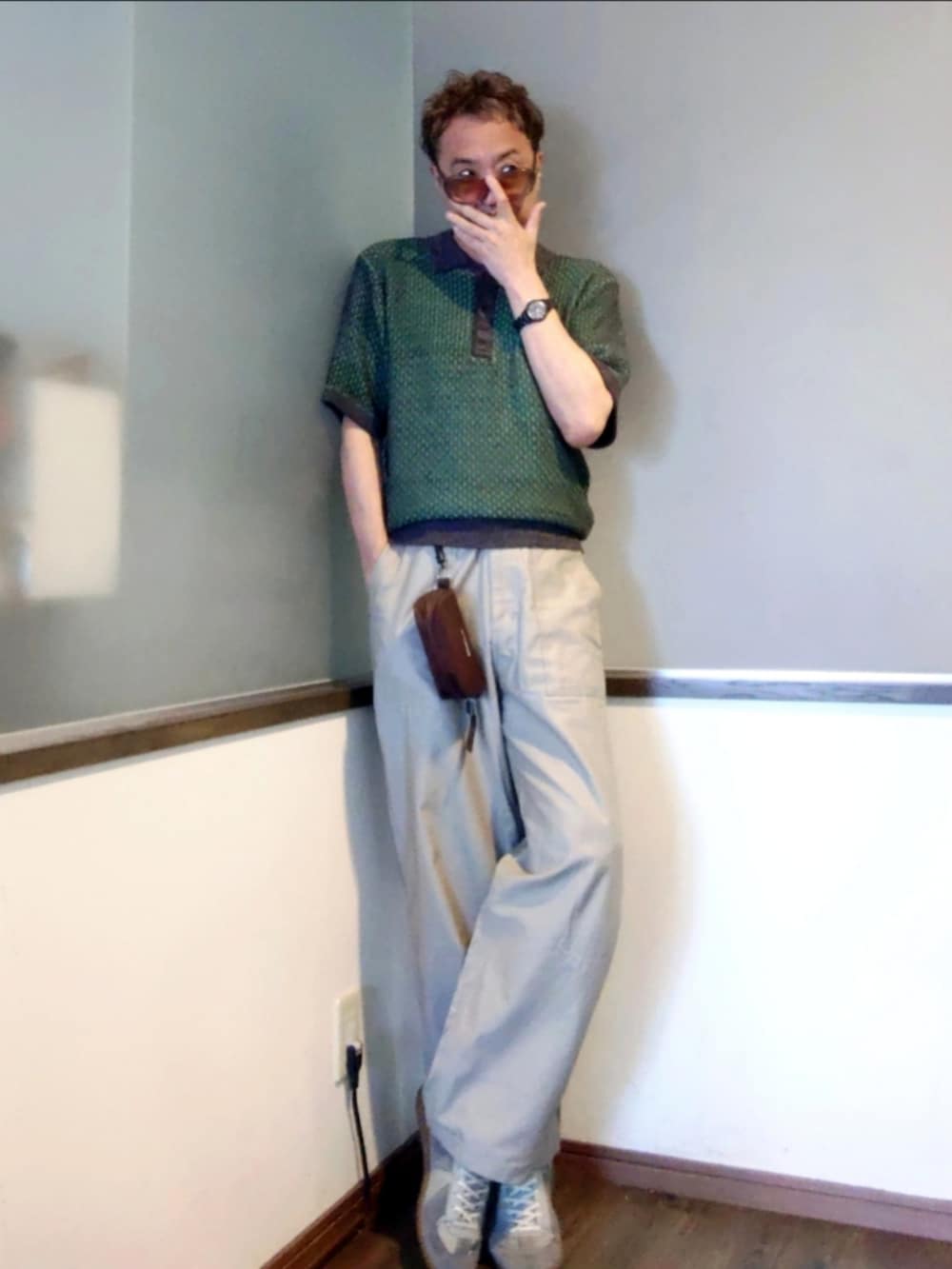 グリーン系のポロシャツ、ベージュ系のその他パンツ、グレー系のスニーカーを着用したメンズの夏コーディネートの2枚目の写真